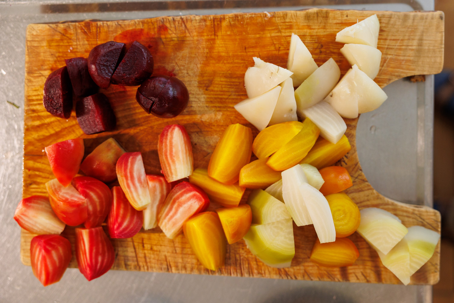 Gulbeta, vitbeta, polkabeta och rödbeta på skärbräda.