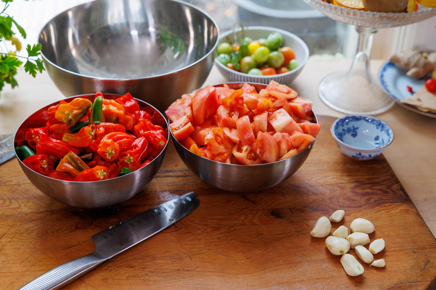 Tomater, chili och vitlök till tacosalsa på skärbräda.