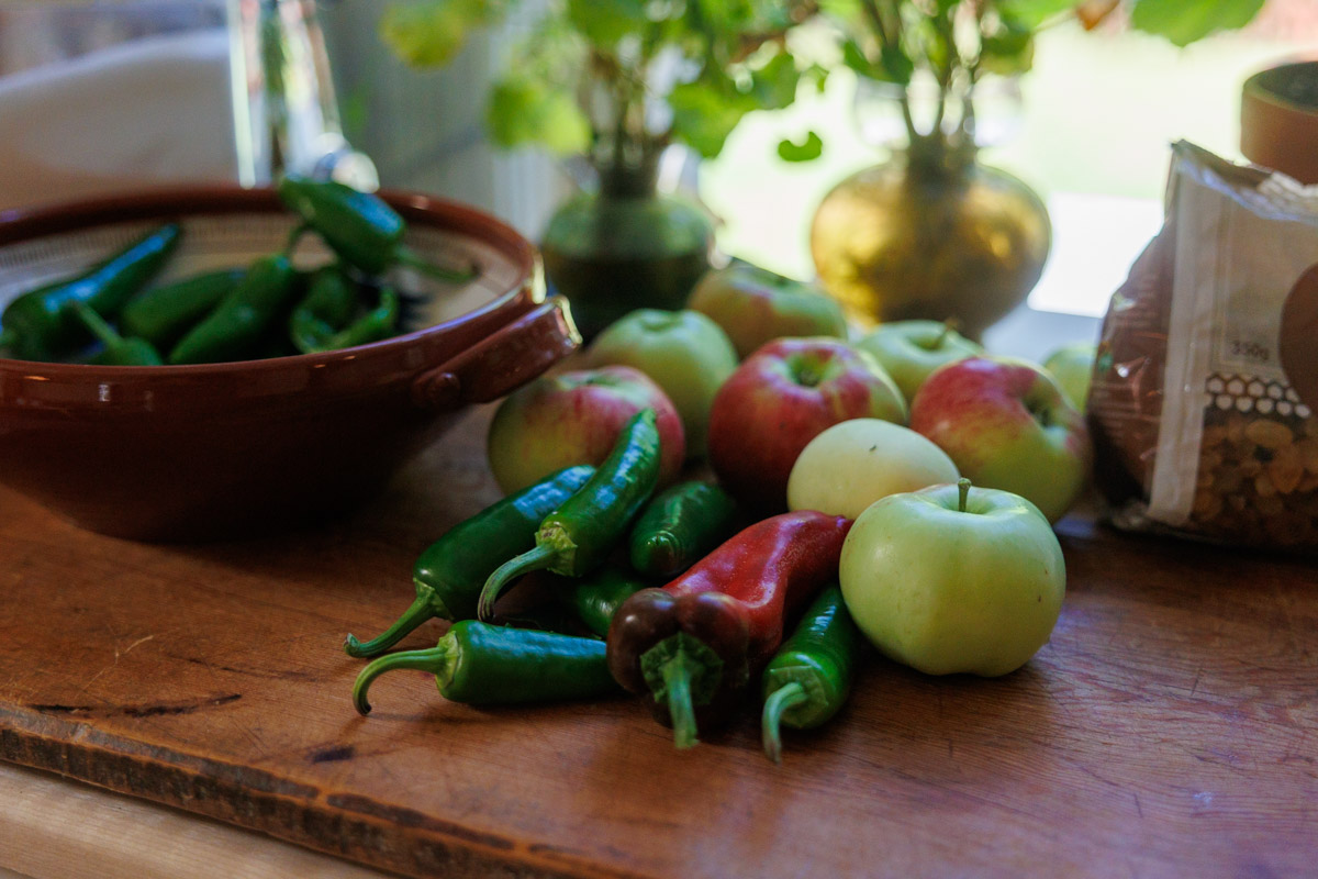 Äpplen och färsk chili på köksbänk inför sweet chilisås